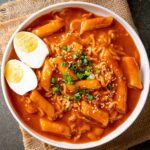 Haşlanmış yumurta ve ramen ile servis edilen tteokbokki.